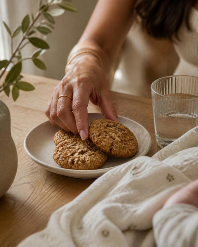 A hand reaching for an oat cookie